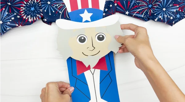hands gluing top to Uncle Sam puppet craft