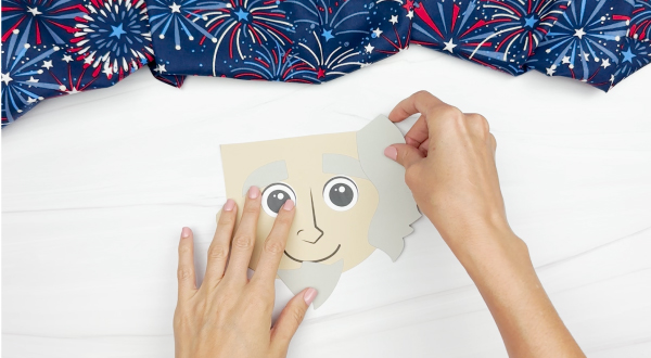 hands gluing hair to Uncle Sam puppet craft