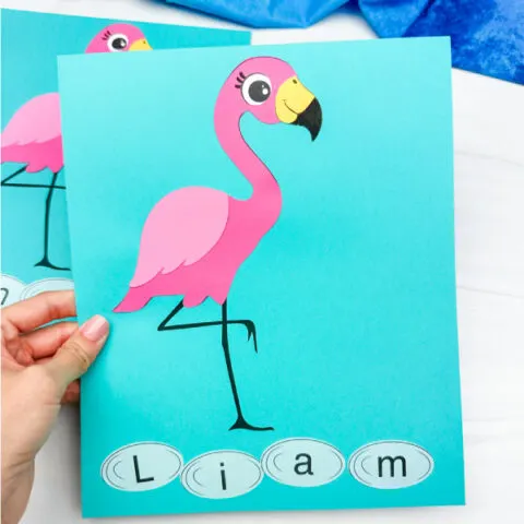 hand holding finished flamingo name craft with another example in the background