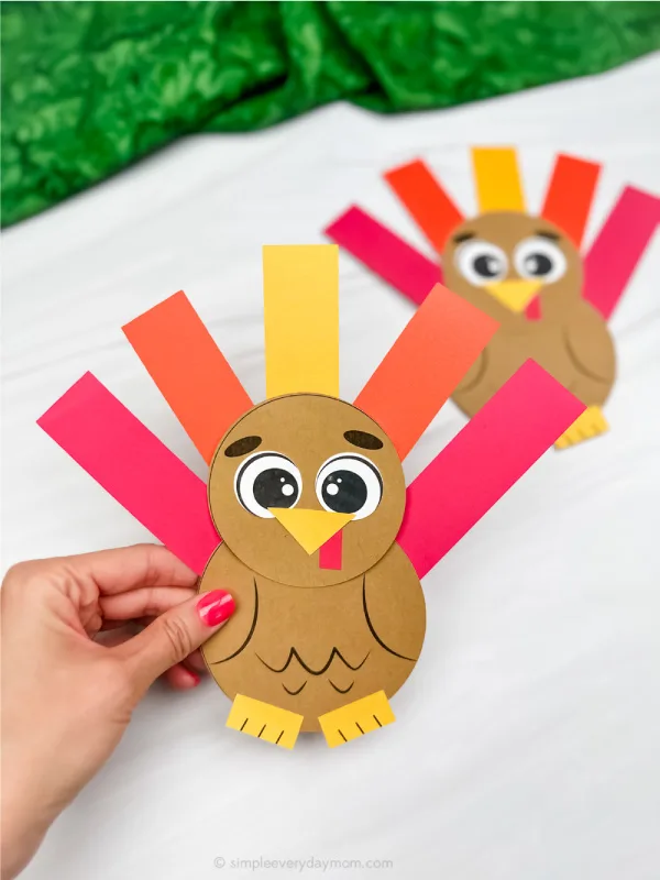 hand holding shape turkey craft with another example in the background