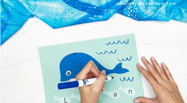 hands using blue marker to draw waves