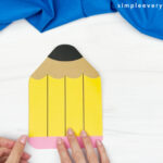 hands gluing paper that represents eraser to end of pencil