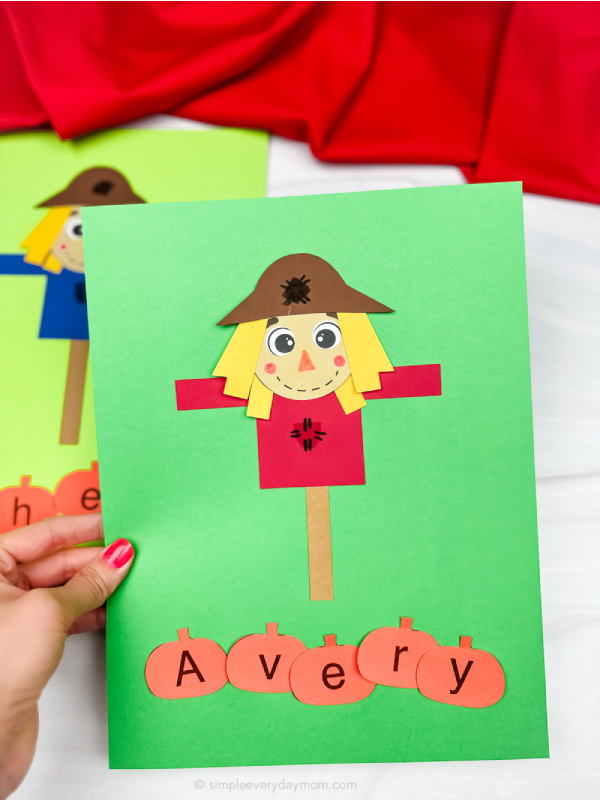 hand holding scarecrow name craft with another in background