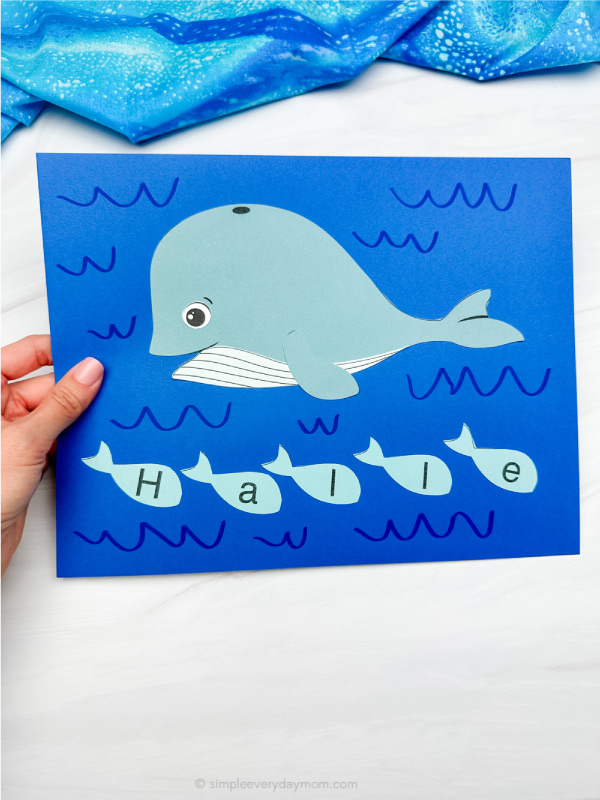 hand holding finished example of whale name craft
