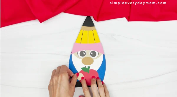 hands gluing hand to back to school gnome craft