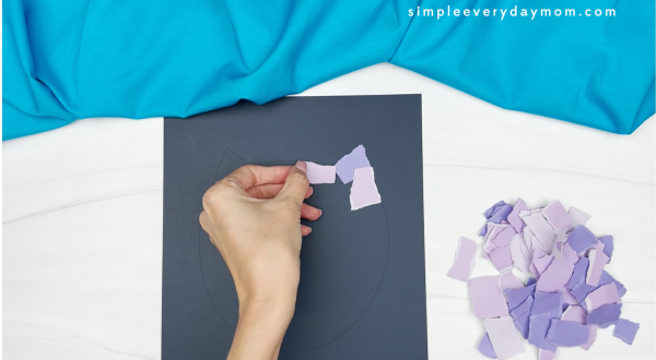 hands gluing purple paper to template