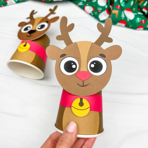 hand holding reindeer paper cup craft with another example in the background