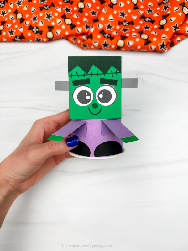 hand holding single example of Frankenstein paper cup craft