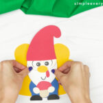 hands gluing gnome to turkey body