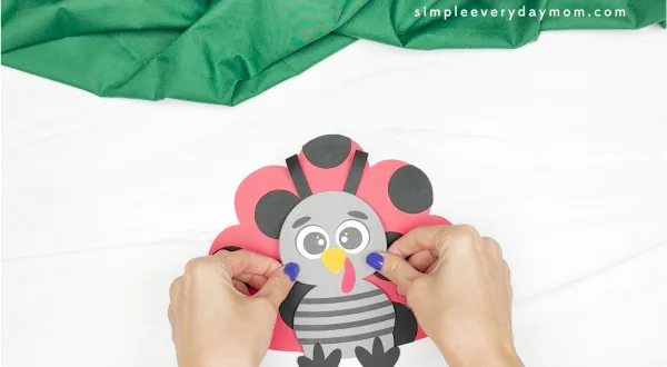hands gluing turkey body to ladybug disguise