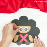 hands gluing turkey eyes to face