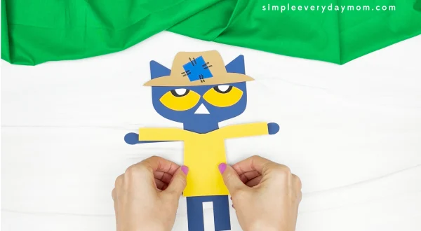 hands gluing shirt to Pete the cat scarecrow craft