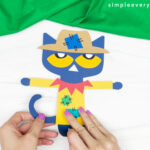 hands gluing tail to Pete the cat scarecrow craft