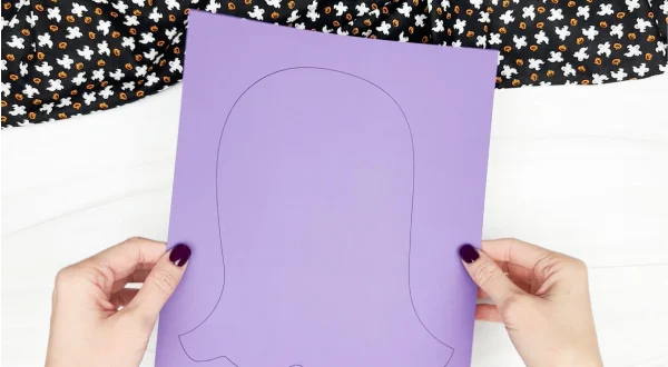 hands holding printed tissue paper ghost template