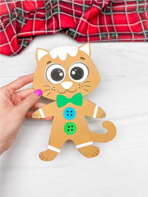 hand holding single finished example of Gingerbread cat craft