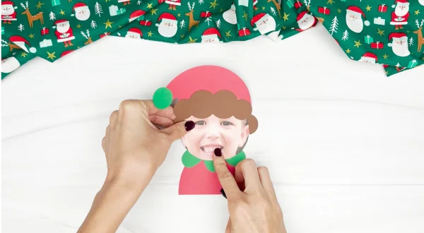 hand gluing the head to the body of photo elf craft