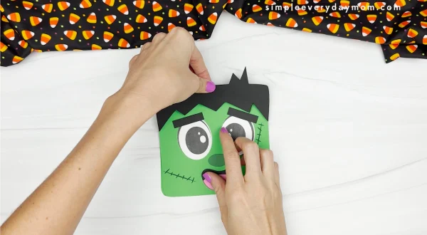 hands gluing hair onto Frankenstein card craft