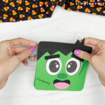 hands gluing parts of Frankenstein card craft