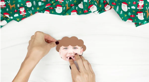 hand gluing the hair of the photo elf craft