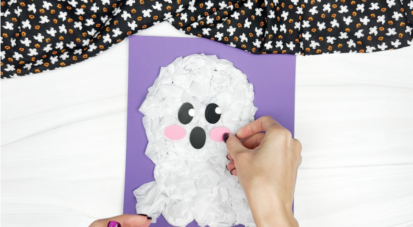 hands gluing cheeks onto tissue paper ghost