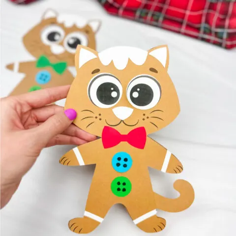 hand holding Gingerbread cat craft with another example in the background