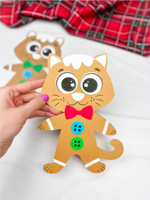 hand holding Gingerbread cat craft with another example in the background