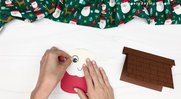 hand gluing the eyes of santa card craft
