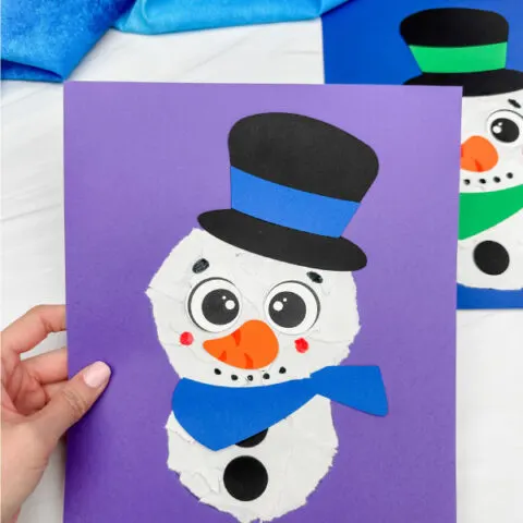 holding the ripped paper snowman craft with background on the side