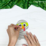 hand gluing the beak of disguise turkey mummy