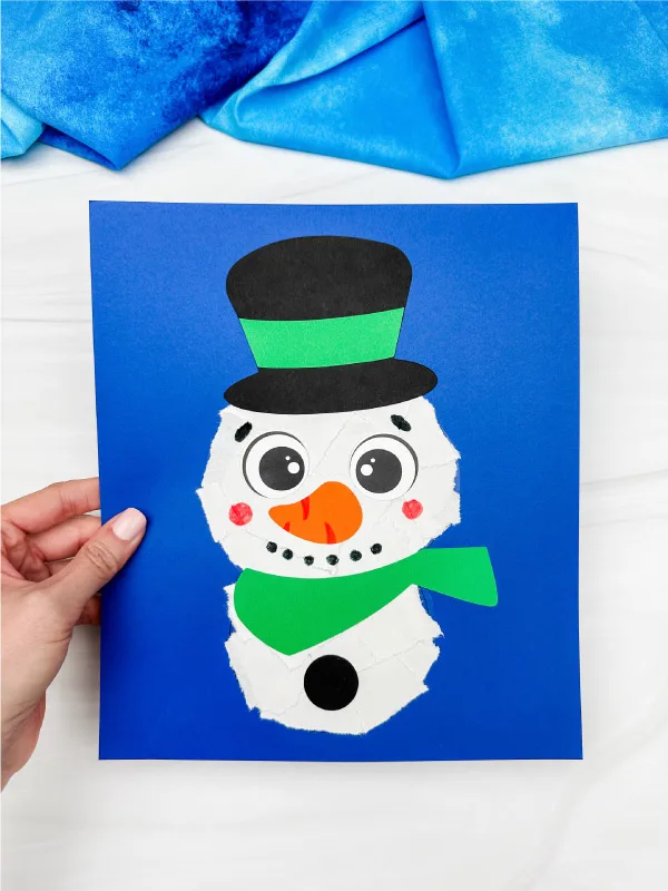 holding the ripped paper snowman craft blue background