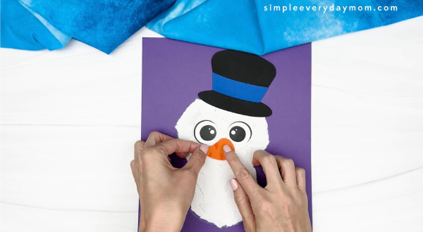 handgluing the nose of the snowman craft