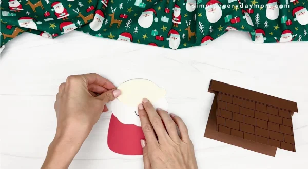 hand gluing the face piece of santa card craft