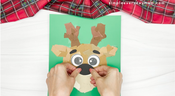 hand gluing the nose of the torn paper reindeer craft