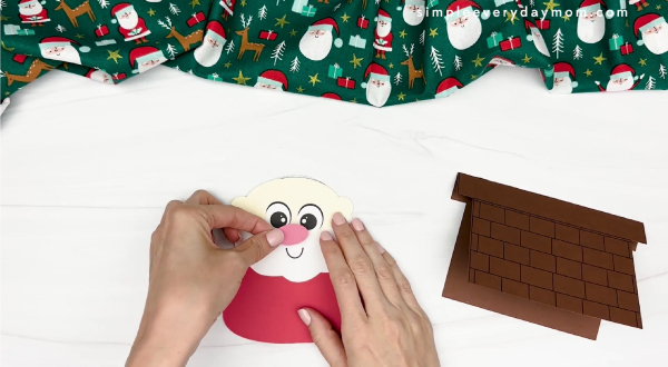 hand gluing the nose of santa card craft