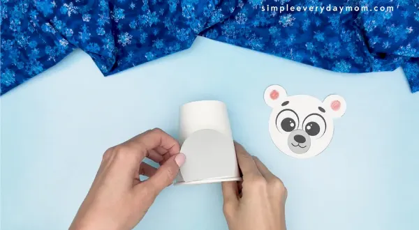hand gluing the belly of polar bear paper cup craft