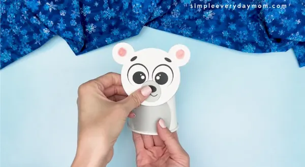 hand gluing the head of the polar bear paper cup craft