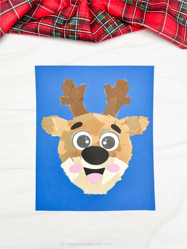 solo picture of torn paper reindeer craft blue background