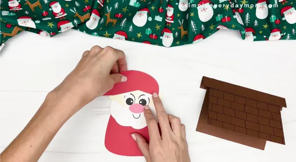 hand gluing the hat of santa card craft