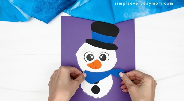 hand gluing the scarf of the snowman craft