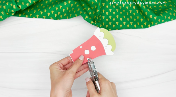 punching the holes in the shoulders of grinch photo craft