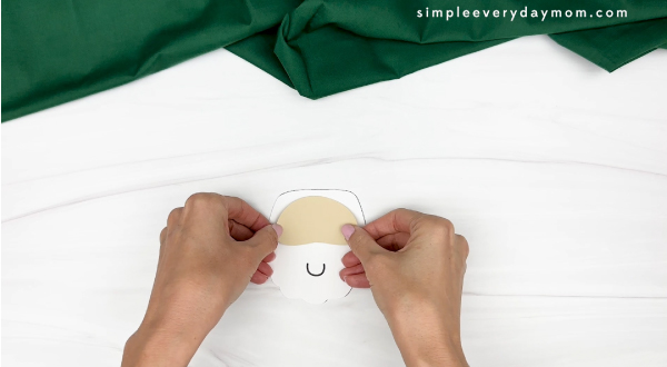 hand gluing the face of santa cup craft
