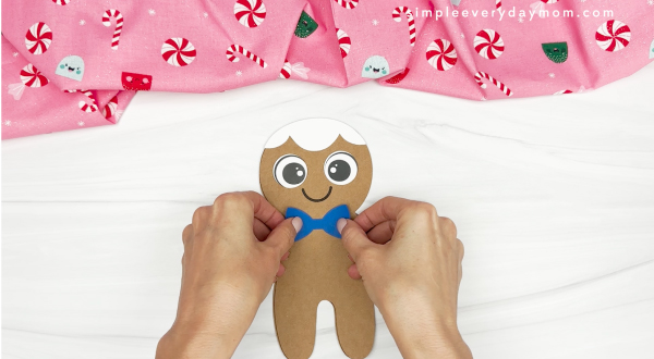 hand gluing the ribbon of gingerbread man