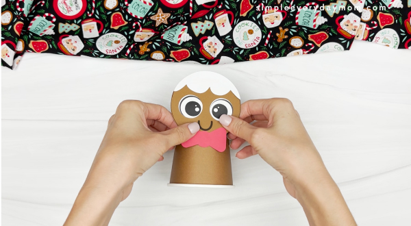 hand gluing the head to the paper cup of gingerbread craft