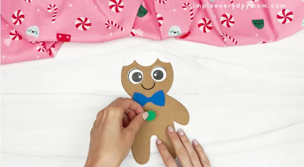 hand gluing the buttons of gingerbread
