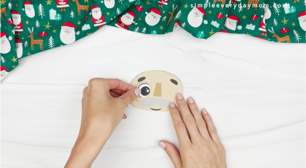 hand gluing the eyes of gnome nutcracker craft