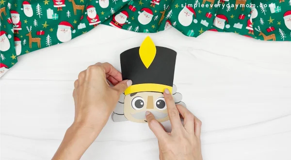 hand gluing the hat to the nutcrackers head
