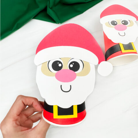 holding the santa cup craft with background in the back