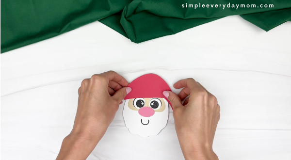 hand gluing the hat of santa cup craft