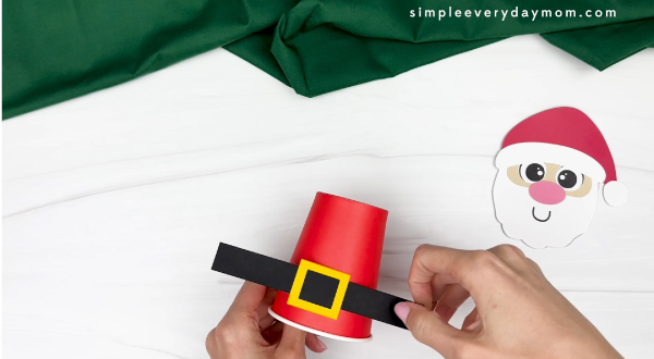 hand gluing the belt in the middle of Santa's cup