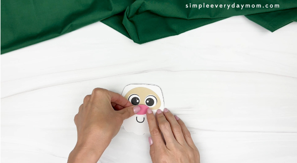 hand gluing the nose of santa cup craft